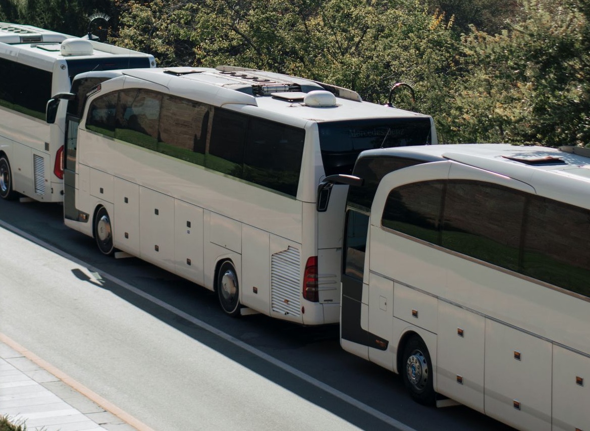 LuxBusExpress luxury motorcoaches staged against downtown Houston city skyline